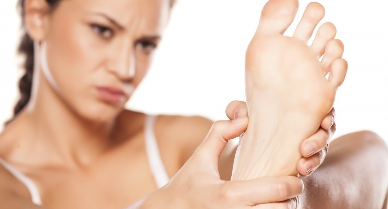 tired young woman massaging her feet