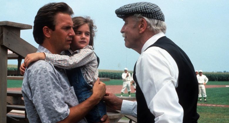 Kevin Costner holding Gaby Hoffmann in a scene from the film 'Field Of Dreams', 1989. (Photo by Universal/Getty Images)