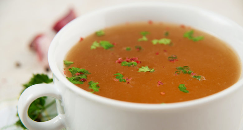 Bone Broth in Small Soup Bowl Served with Fresh Herbs, Garlic and Spices; Shutterstock ID 144087859; PO: TODAY.com