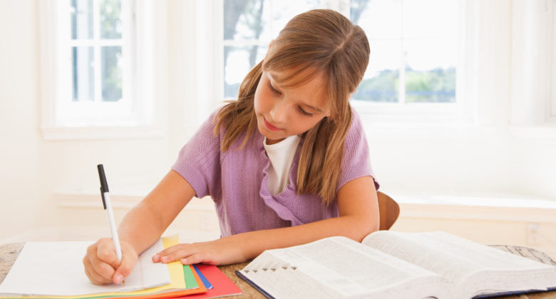 Young girl doing homework at kitchen table