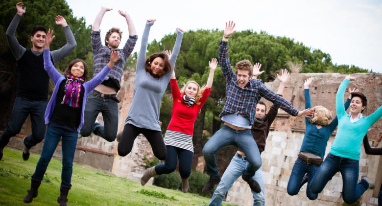 Group of Happy College Students Jumping at Park,Italy